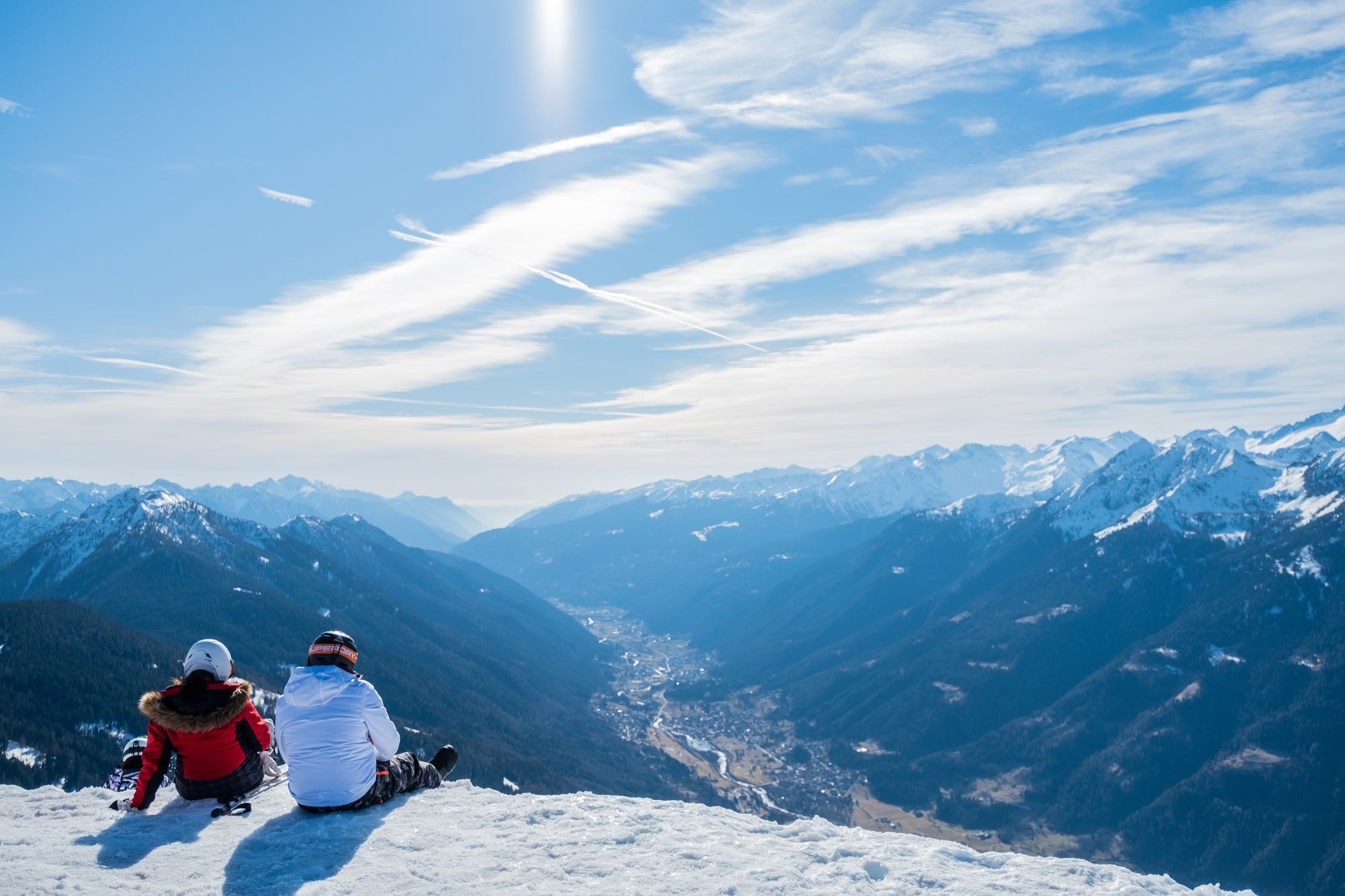 Alpensicht mit zwei Skifahrer sitzend im Vordergrund